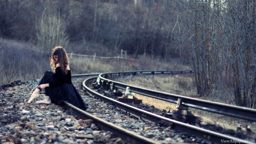 A Girl Sitting On A Railway Track