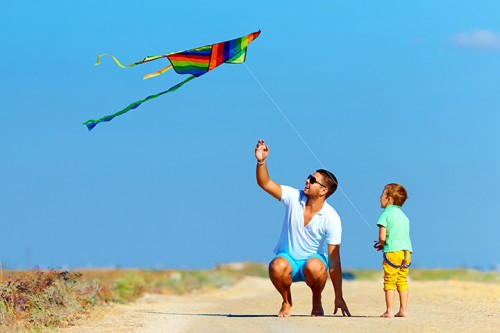 Kid fly a kite with dad