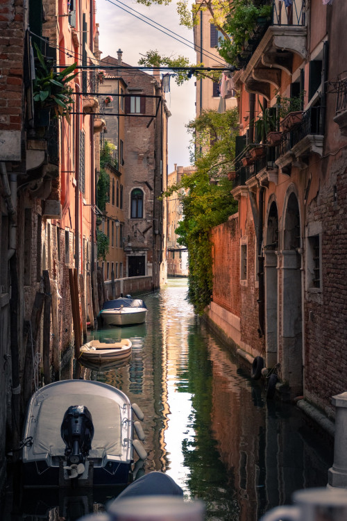 A view of a canal with some boats in Venice, Italy