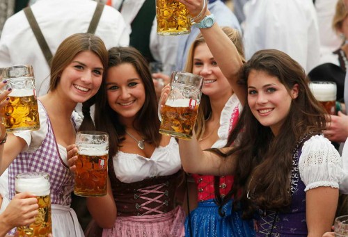 Young women cheer with beer mugs