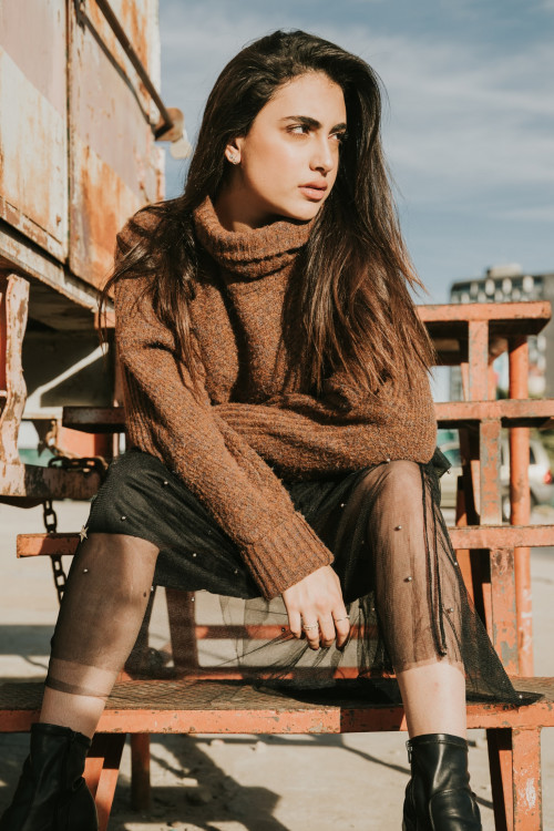 Woman in Brown sweater and sitting on brown bench
