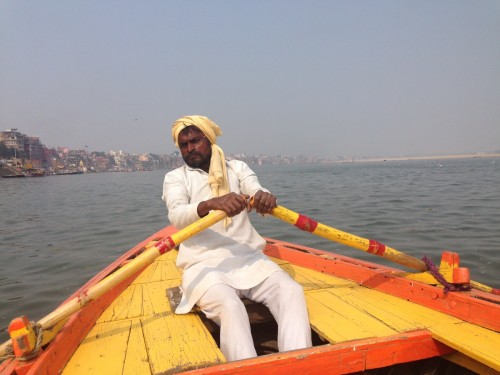 Person rowing a boat in the Ganges. Hard work for earning his daily wages.